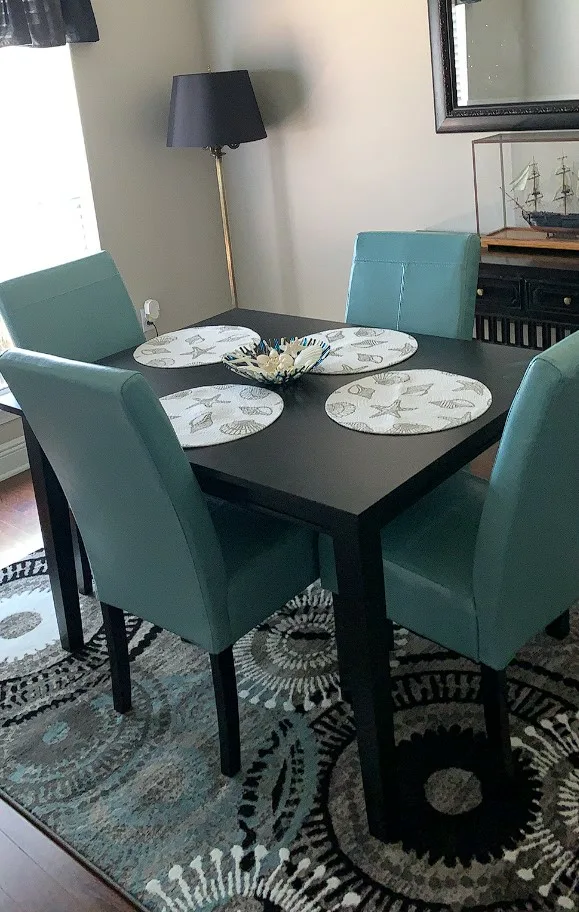 Black Rectangular Dinner Table Wood Painted Smooth Surface With Cusioned Green Chairs