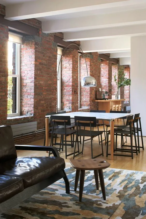 Industrial Dinner Table With Black Sleek Chairs And Brick Walls