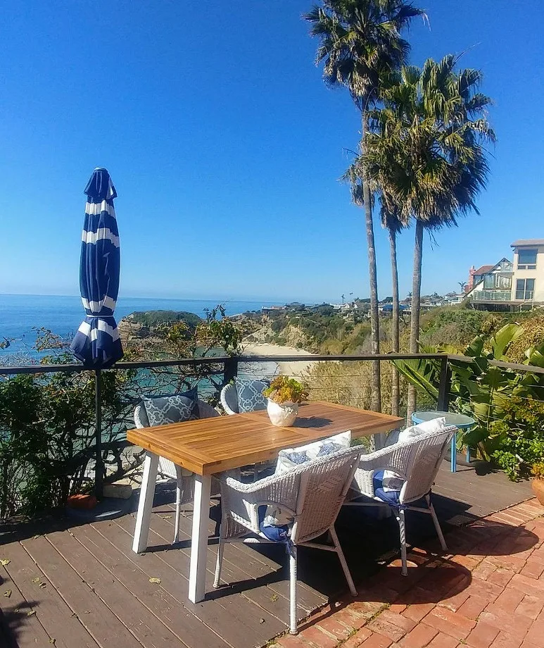 Outdoor Dinner Tables Wood Top And Whited Painted Base On Over Looking View Of A Beach