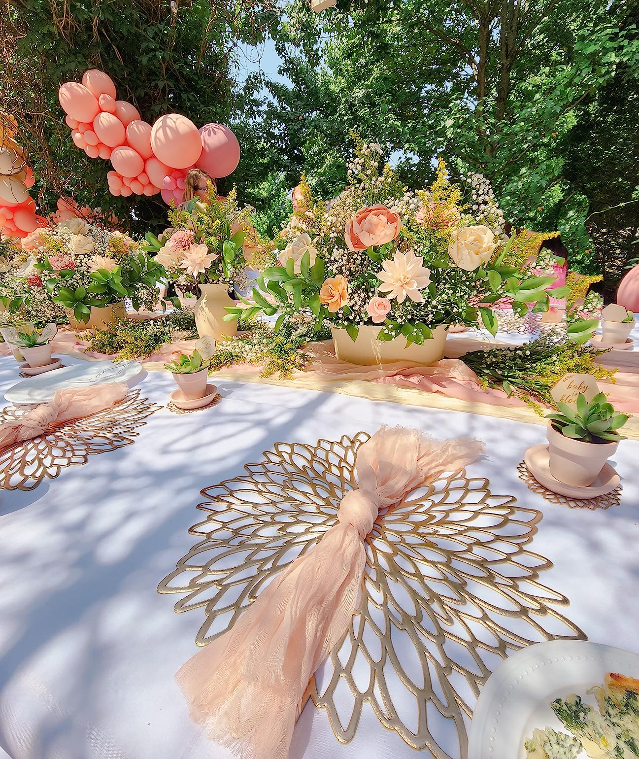 Gold Placemats Pink Sheer Napkins Tablerunner Flowers Trees Angle View Dinner Table Setting