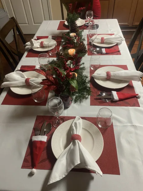 Red Placemats Santa Hat Cutlery Holder Pine Leavees Garland Centerpiece White Tablecloth Top View Dining Tables