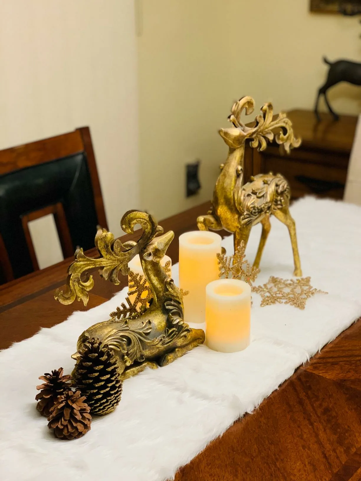 White Tablerunner Gold Reindeers Figurines Centerpiece Warm Ledcandles Side Angle View White Christmas Table Decorations