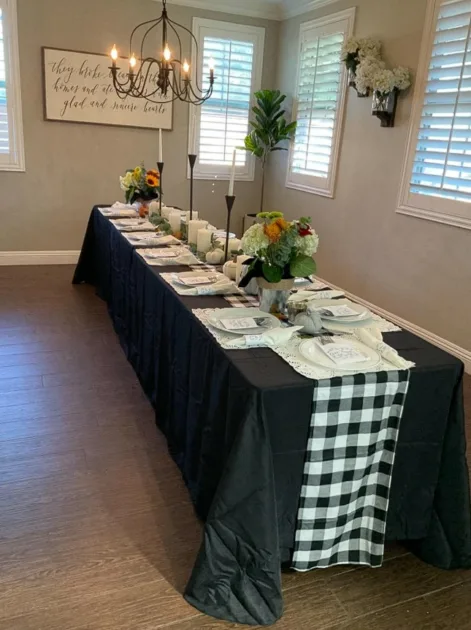 Tablescape Ideas For Fall Black Tablecloth With Checkered Tablerunner And Floral And Candle Holder Centerpiece